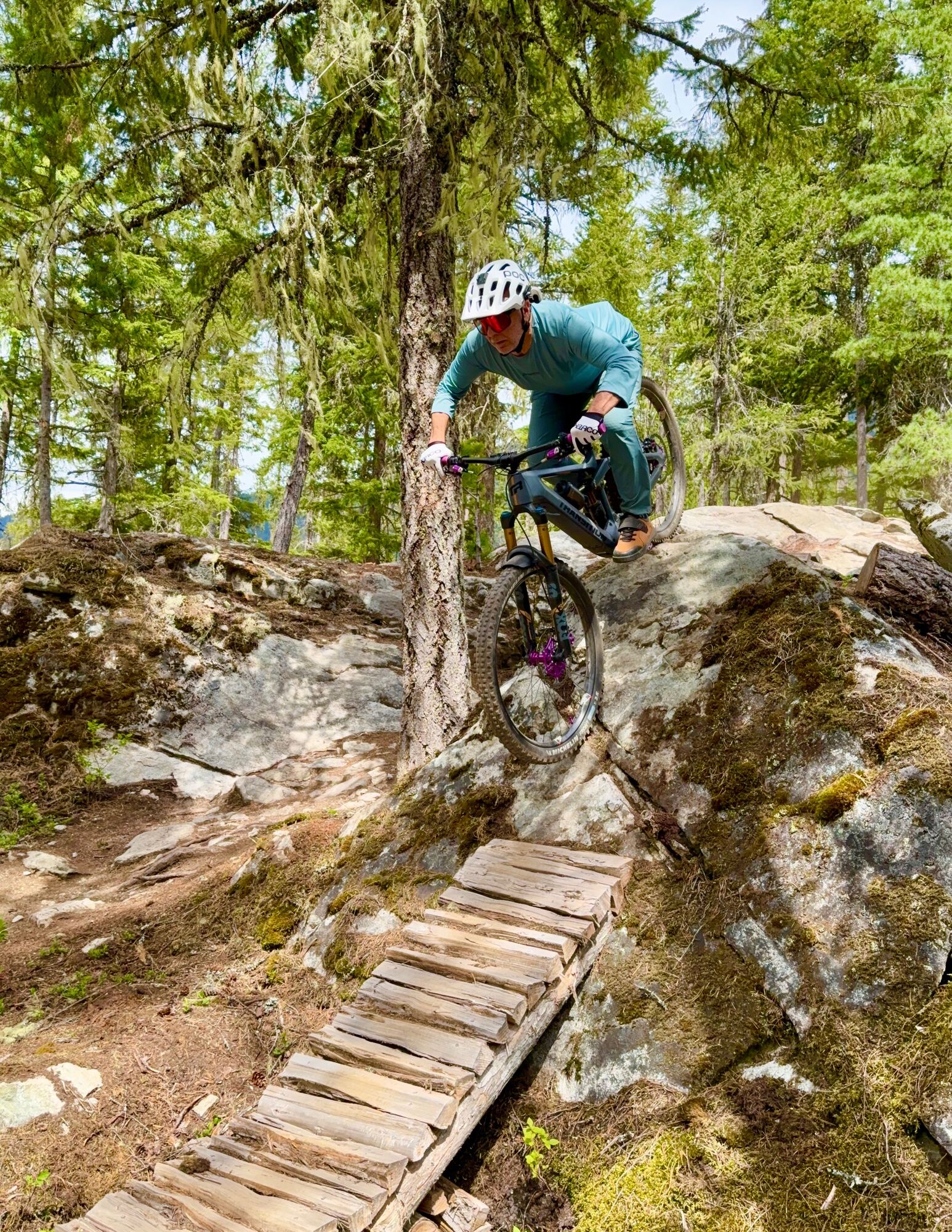 Rider threading a wooden skinny over a rock slab
