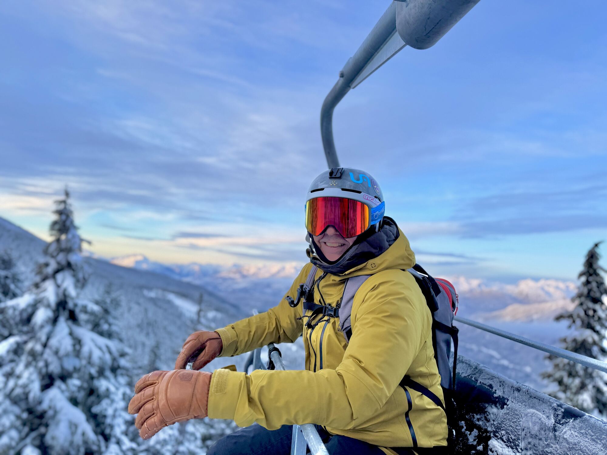 Skier on a chairlift at golden hour above the valley